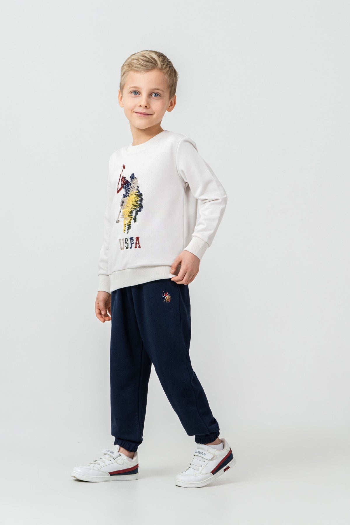 U.S. Polo Assn. krem komplet trenerke za dječake s velikim motivom jahača i teget hlačama