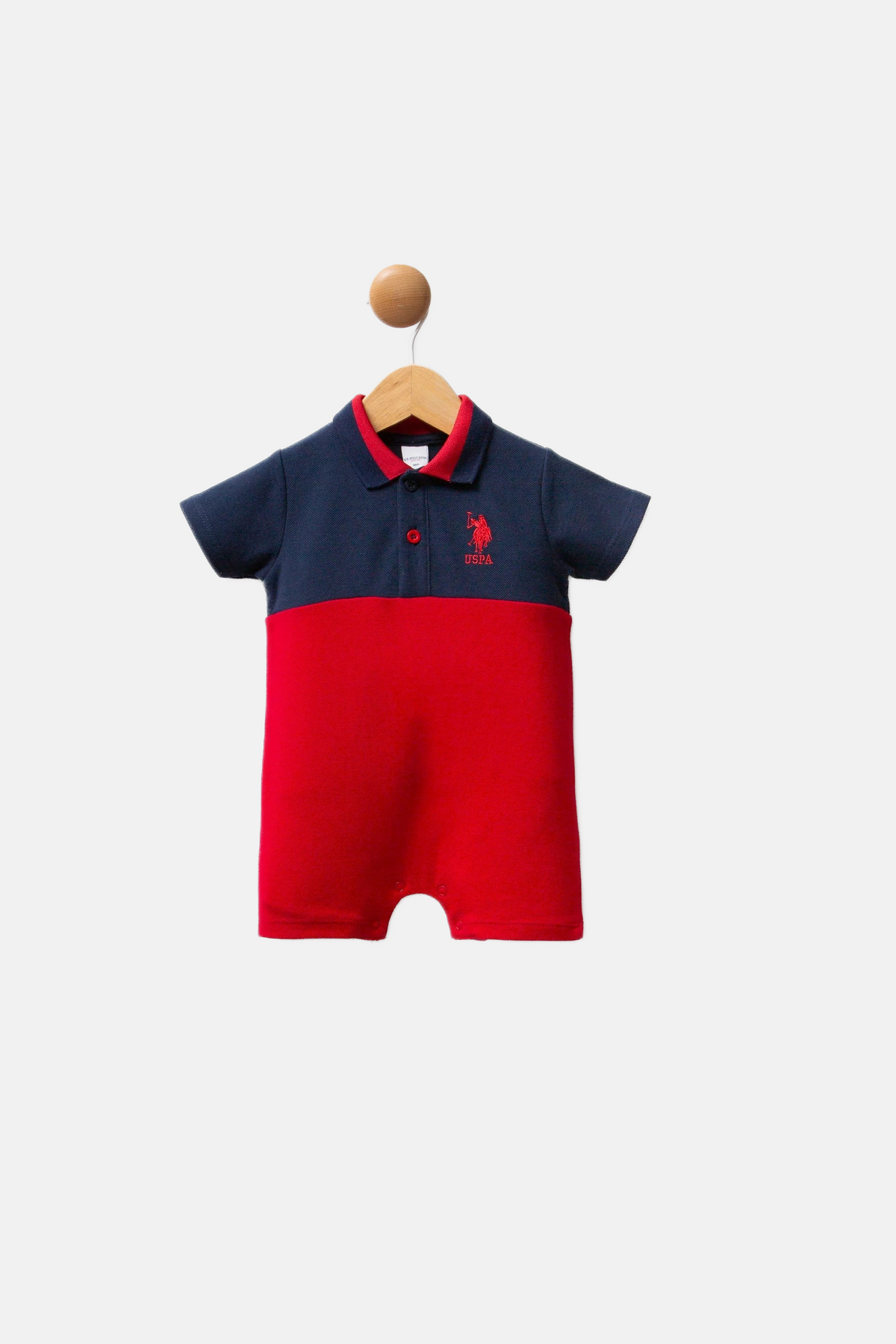 U.S. Polo Assn. teget plavi kombinezon za bebe s crvenim detaljima