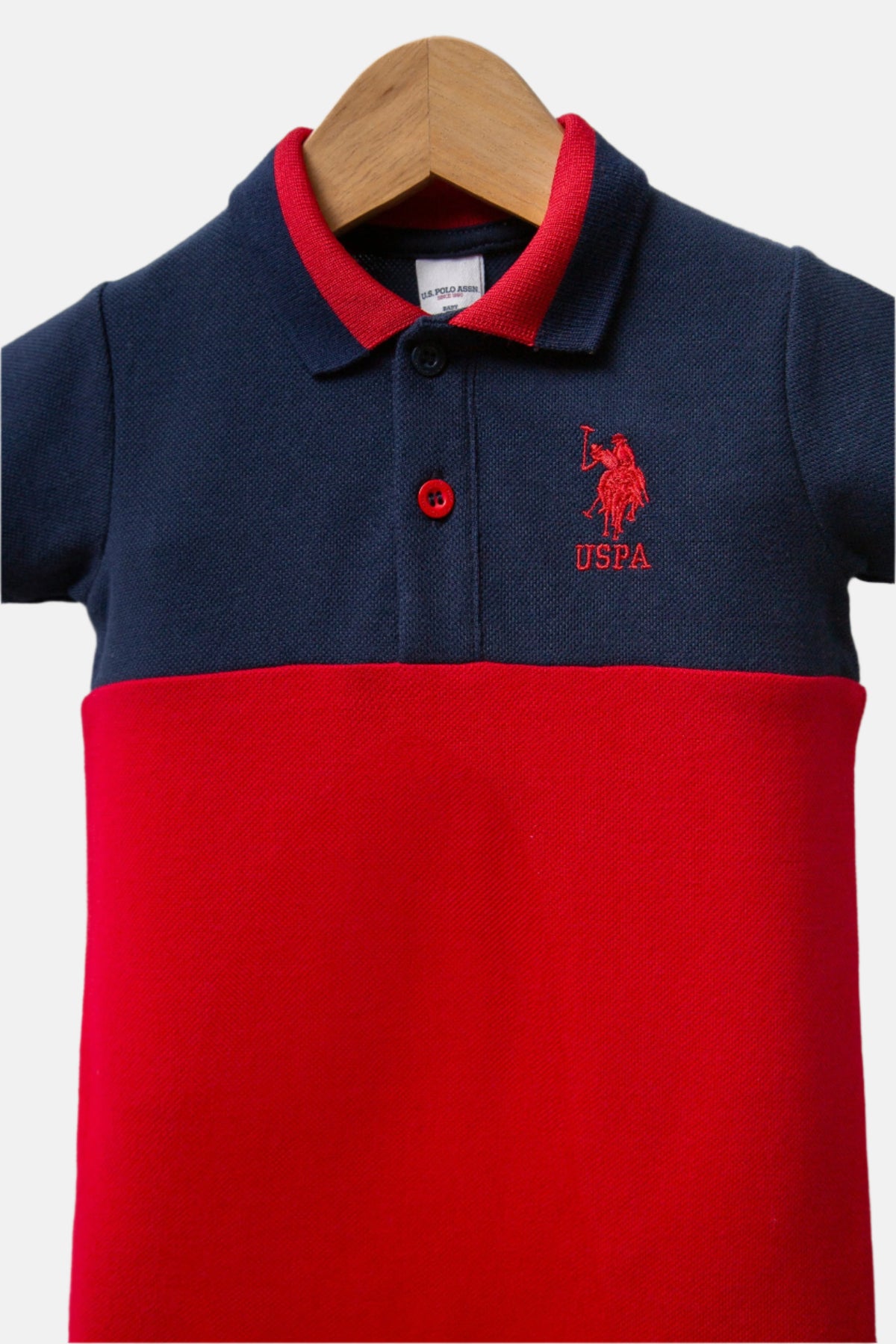 U.S. Polo Assn. teget plavi kombinezon za bebe s crvenim detaljima